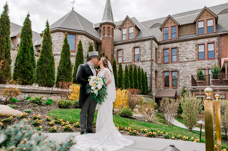 Groom and bride kissing with building background